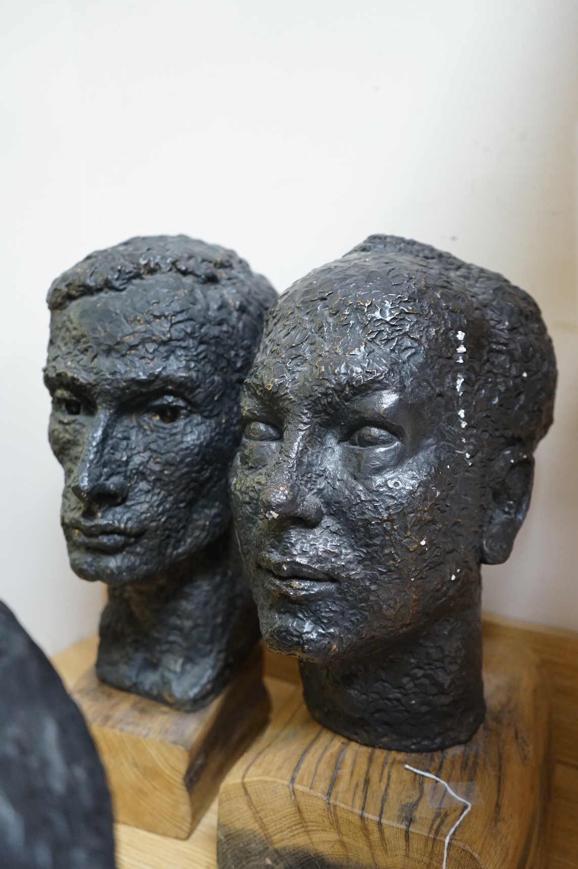 Six black painted composition heads, by Hazel Armour, tallest 49cm